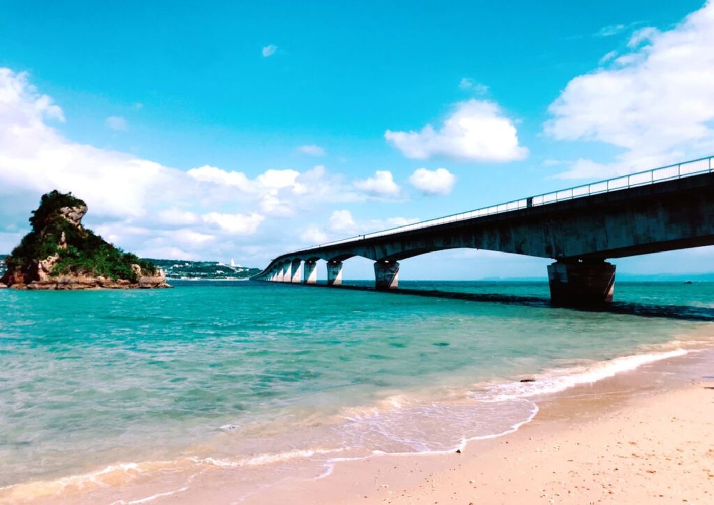 古宇利大橋と、桜色に見える砂浜と青い海