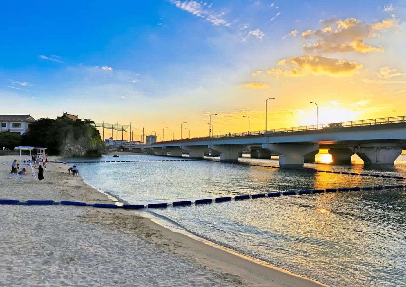 波の上ビーチの海と、上を横切る那覇西道路の高架、夕日