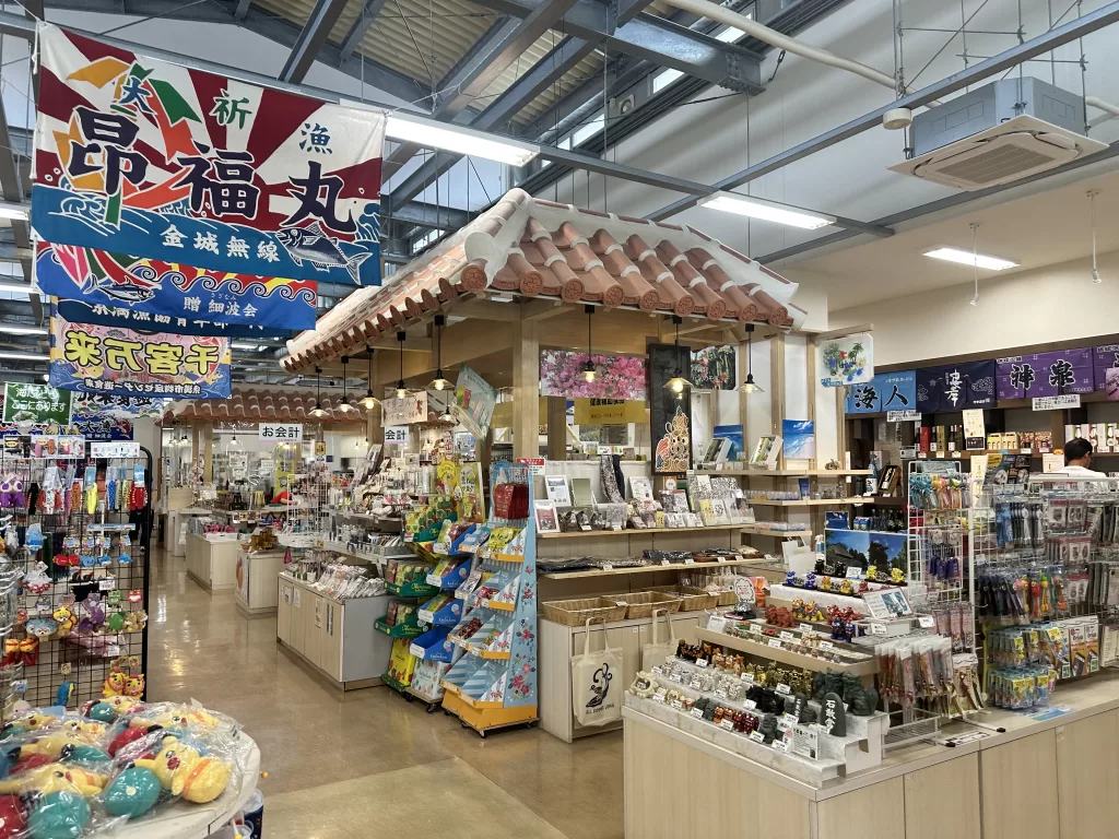 遊食来の土産売り場。大漁旗の下に土産物の棚が並んでいる
