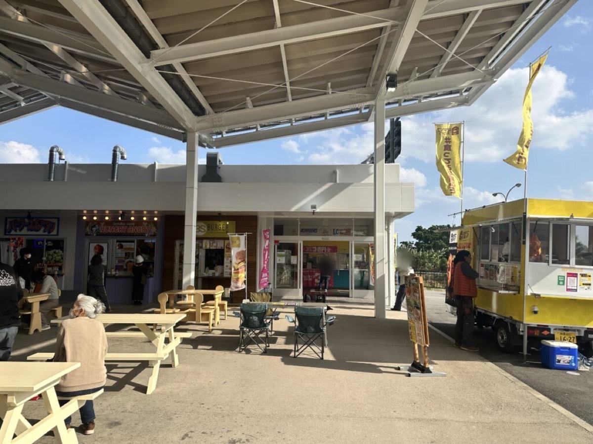道の駅かでなの屋外イートスペース。テーブルと椅子が並ぶ