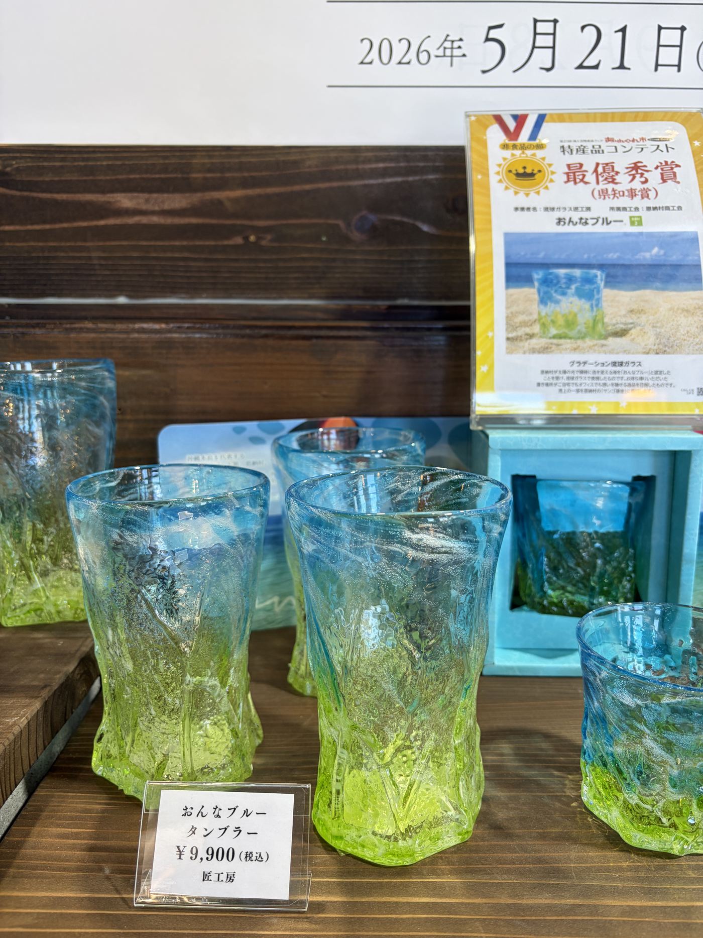 特産品コンテスト最優秀賞（県知事賞）の表示とおんなブルーのタンブラー