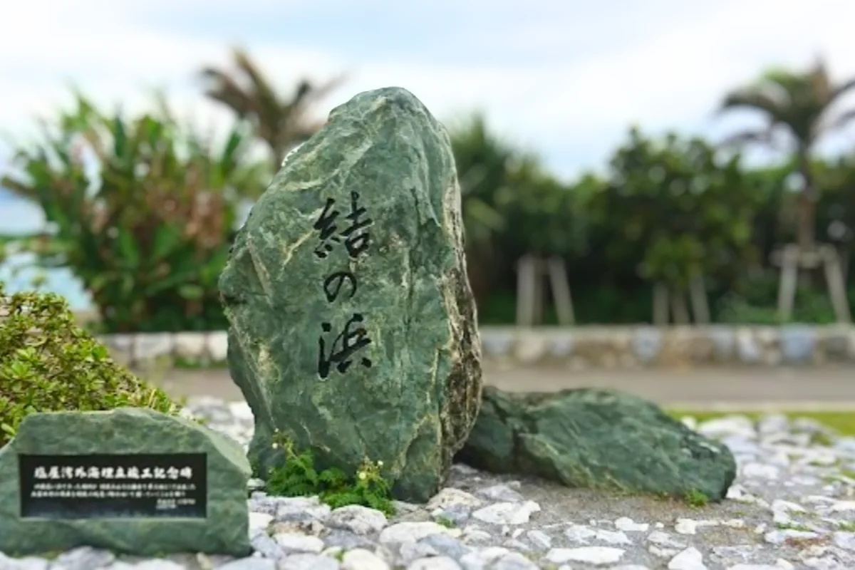 結の浜公園の入口に立つ「結の浜」の石碑と、その向こうの海