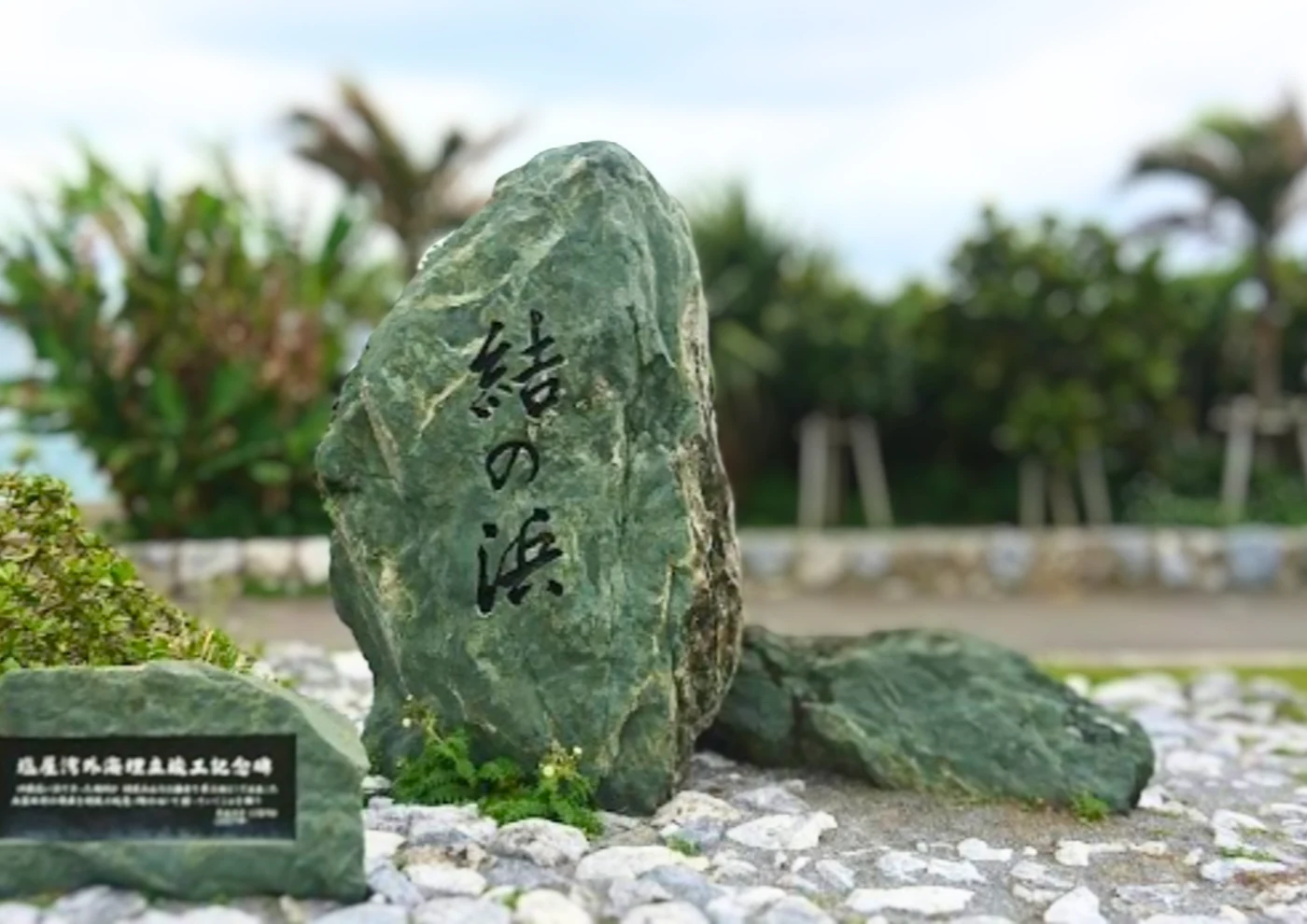結の浜と刻まれた石碑と、その向こうに広がる海